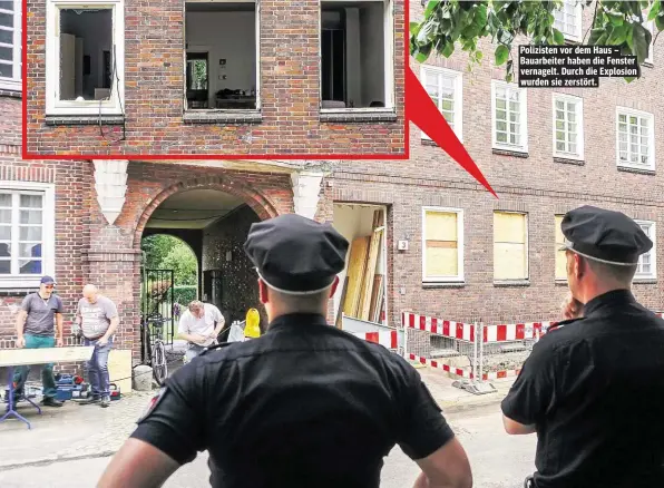  ??  ?? Polizisten vor dem Haus – Bauarbeite­r haben die Fenster vernagelt. Durch die Explosion wurden sie zerstört.