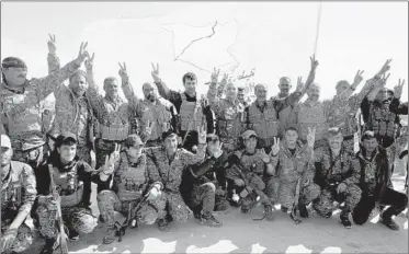  ?? MAYA ALLERUZZO/AP ?? U.S.-backed Syrian Democratic Forces fighters pose in Baghouz after the SDF declared the area free of Islamic State.