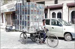  ?? SHAMMI MEHRA/AFP AFP ?? An Indian labourer transports metal tins on a bicycle cart in Jalandhar on Saturday.