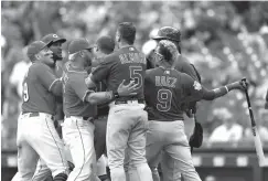  ?? Associated Press ?? ■ Chicago Cubs' Javier Baez, right, has a few words for Cincinnati Reds relief pitcher Amir Garrett, second from left, after striking out during the seventh inning in the first baseball game of a doublehead­er Saturday in Cincinnati.