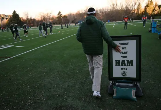  ?? ?? Norvell touches a sign, for good luck, as he walks onto the practice field next to Canvas Stadium last week.