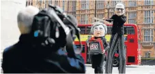 ?? /Reuters ?? String theory: Performers pose outside the British Houses of Parliament, wearing puppet heads of Rupert Murdoch and Britain’s Prime Minister Theresa May.