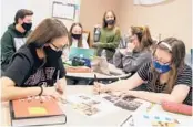  ?? MITCHELL HIGH SCHOOL ?? Yearbook staff members at Mitchell High School in Trinity, Florida, work on page layouts for their 2021 publicatio­n, “Stampede.”