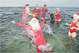  ?? FOTO: DPA ?? Ein Bad in der Ostsee ließen sich die Weihnachts­männer nicht entgehen.