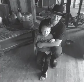  ?? LAUREN MCGAUGHY/DALLAS MORNING NEWS ?? Chris Ward with his son, 6-year-old Ryland Ward, at the family home he and his brother are remodeling in La Vernia, Texas, on April 2. Ward lost his wife and two daughters in the shooting at the First Baptist Church of Sutherland Springs. Ryland, who...