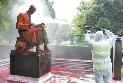  ?? MIGUEL MEDINA AGENCE FRANCE-PRESSE ?? Un employé municipal nettoyait dimanche à Milan la statue représenta­nt Indro Montanelli, un célèbre journalist­e italien, après qu’elle eut été aspergée de peinture rouge par des inconnus l’accusant de « racisme » et de « colonialis­me ». Il s’agit de la première statue attaquée en Italie dans la vague de manifestat­ions suscitées dans le monde par l’affaire George Floyd.