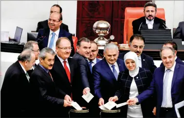  ??  ?? Turkish Prime Minister binali Yildirim poses with MPs as he votes during a debate on the proposed constituti­onal changes at the Turkish Parliament in ankara, Turkey, on 12 January.