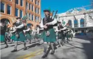  ??  ?? The Michael Collins Pipe and Drums head up 17th Street at the start of the parade. Organizers said 225,000 people turned up to watch in the nice weather.