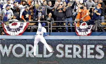  ?? Wally Skalij/ Los Angeles Times/TNS ?? Los Angeles Dodgers right fielder Yasiel Puig climbs the wall but can’t reach a solo home run ball hit by the Houston Astros’ George Springer in the third inning during Game 6 of the World Series on Tuesday at Dodger Stadium in Los Angeles. The Dodgers won, 3-1, forcing a Game 7. This will be the third World Series Game 7 in four years. Ten of the last 12 teams that won Game 6 to force a seventh game also won the title, but the Dodgers lost the previous six World Series in which they trailed 3-2. They have won just one of their six championsh­ips at home, in 1963.