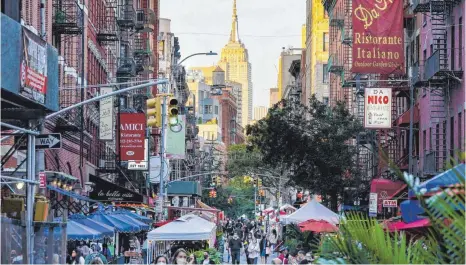  ?? FOTO: JOHN MINCHILLO/DPA ?? Menschen schlendern durch eine Straße in New York – in kleinen Schritten der Normalität entgegen, auf die sie alle hoffen.