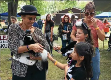  ?? CAROL HARPER — THE MORNING JOURNAL ?? Cindie Vanderbur from Dupont, Ind., holds two-year-old Clarkson dressed as a “steam punk skunk” Sept. 9 at SkunkFest 2017 at South Central Park at 7565 Avon Belden Raod in North Ridgeville. The girls, Lillian McDaniel, seven, Medina, and Gabriella...