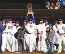  ?? AP ?? Chicago Cubs players walk the field carrying the 2016 World Series Championsh­ip trophy on Monday.