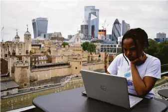  ?? Urooba Jamal / Associated Press ?? Rebekah Ingram, an intern at Like Minded Females Network, works on her laptop at a WeWork location in London. Britain’s economic growth slowed more than expected in July.