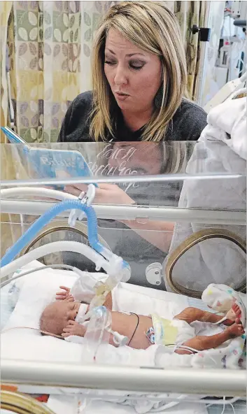  ?? DAVID WOO TNS ?? Anna Aguilar reads a book to her son, Cannon Aguilar, 8-weeks-old. Cannon was one pound and two ounces at birth. Research has shown the benefits of reading, not only to toddlers but also to infants and preemies.