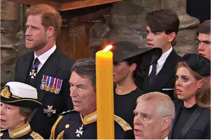  ?? ?? Out of sight: Meghan is behind Commander Tim Laurence – and a large candle