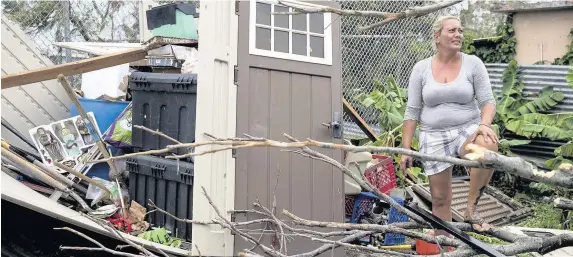  ?? Alex Wroblewski ?? > A resident surveys the damage to her property after Hurricane Maria made landfall in San Juan, Puerto Rico