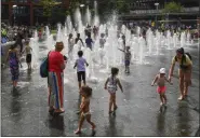  ?? ANTHONY DEVLIN — THE ASSOCIATED PRESS ?? People splash in the fountains at Piccadilly Gardens in central Manchester, England, on Thursday.