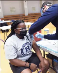  ??  ?? Leah Moore, 17, receives her first dose of the Pfizer COVID-19 vaccine from New Haven City Health Department RN Arbrim Sejdiu at the clinic.