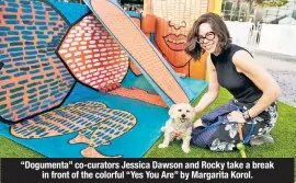  ??  ?? “Dogumenta” co-curators Jessica Dawson and Rocky take a break in front of the colorful “Yes You Are” by Margarita Korol.