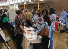  ?? JEREMY P. KELLEY / STAFF ?? Teresa Greer (left) with the Dayton VA Dental Service gives tips to Ponitz Career Tech Center students who are certified as dental assistants during a career event. Plans call for Ponitz to offer classes in 13 career parthways in the fall. Meadowdale, set to become a career tech center, will offer 10 parthways.