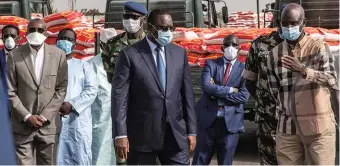  ??  ?? A Dakar, au Sénégal, le 12 avril, le président Macky Sall inspecte les lots de nourriture destinés à être distribués dans le cadre de l’aide alimentair­e d’urgence.