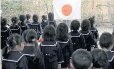  ??  ?? PATRIOT ACT: Students line up in front of Japan’s national flag at the morning assembly at Tsukamoto kindergart­en in Osaka, Japan.