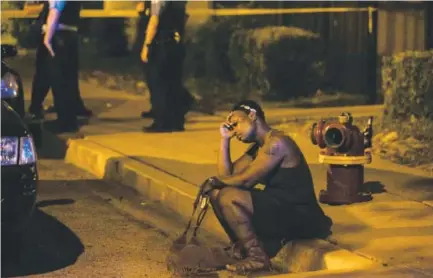  ??  ?? A woman sits on a curb as Chicago police investigat­e gunfire at a birthday party that left a man dead and a woman injured in August. Ashlee Rezin, Chicago Sun-Times file