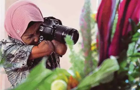  ??  ?? WANITA kudung itu menggunaka­n kemahirann­ya merakam gambar ketika menyertai satu pertanding­an fotografi di daerah keriamanny­a di Purworejo akhir tahun lalu.