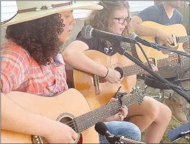  ?? (NWA Democrat-Gazette/Lynn Kutter) ?? Patience Remington of Lincoln sings at the Prairie Grove Farmers Market. She has learned to play guitar through Roots Music, a free program sponsored by Historic Cane Hill through Inside Out Studio in Farmington.