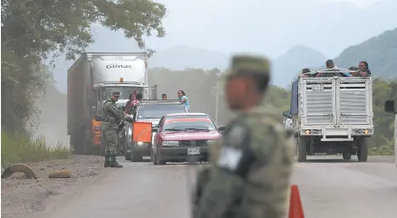  ??  ?? • Soldados de la Guardia Nacional coordinan un retén temporal para detectar a migrantes, justo al Norte de Ciudad Cuauhtémoc, Chiapas.
