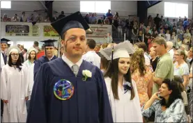  ??  ?? Seniors Sergio Bussell and Zoe Goulet march into the Burrillvil­le High School graduation ceremony during the procession­al.