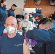  ?? SEAN D. ELLIOT/THE DAY ?? Coast Guard Academy Superinten­dent Rear Adm. Bill Kelly, left, gets his first dose of the Pfizer BioNTech COVID-19 vaccine from Health Services Technician 3rd Class Justin Boulanger as personnel at the U.S. Coast Guard Academy are vaccinated Tuesday in the academy’s Leamy Hall.