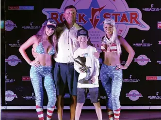  ?? ?? Thanks to his two blue marlin and six sailfish releases, Jonah Smith was presented the Top Junior Angler trophy during the tournament. His proud grandfathe­r, Ted, joined him onstage.
