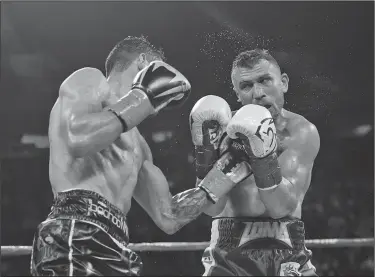  ?? Associated Press ?? Tough fight: Jorge Linares,left, of Venezuela, connects with Vasiliy Lomachenko, of Ukraine, during their WBA lightweigh­t championsh­ip boxing match Saturday in New York.