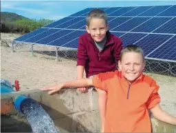  ??  ?? BO: Daniel (11, voor) en Nikosau (6) Erasmus is baie opgewonde oor die groot klomp water wat by dié pyp uitkom. Water word met sonkrag teen 60 000 liter per uur na ‘n kophoogte van 60 m gepomp. LINKS: Hierdie sonkragpom­p lewer 26 000 liter per uur op...