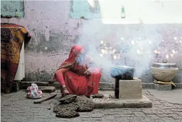  ?? /Bloomberg ?? Suffer the women: Smoke bellows from a domestic hearth known as a ‘chulha’, which uses dung cakes, made from the by-products of animal husbandry, as cooking fuel at a village in Greater Noida, Uttar Pradesh, India.