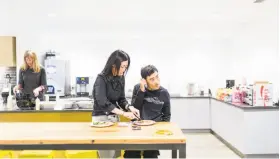  ?? Jason Henry / New York Times ?? Jini Kim helps her autistic brother Kimong with his lunch at the Nuna headquarte­rs in San Francisco. His care is shared among family members.