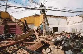  ?? REUTERS PIC ?? A man walking among the debris of a house on Friday, in Juchitan de Zaragoza, Mexico.