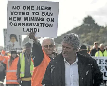  ?? IAIN MCGREGOR/ STUFF ?? Cabinet Minister Damien O’Connor from the West Coast gets a message from protesters at the opening of the Taramakau bridge.