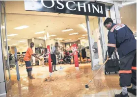  ?? Picture: Jacques Nelles ?? WEATHERED. Staff sweep the water in the Foschini store at the Jubilee Mall in Hammanskra­al in Tshwane yesterday.