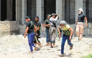  ?? AFP ?? Determined defenders Fighters of the Popular Committees loyal to Yemen’s President Abd Rabbo Mansour Hadi take positions during clashes with Al Houthi rebels in Aden’s Dar Saad suburb yesterday.