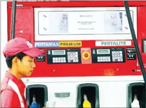  ?? NUGROHO ADI/THE JAKARTA POST GANUG ?? An attendant serves a customer at a fuel station in Surakarta, Central Java.