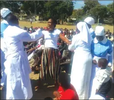  ??  ?? Madzibaba Masango casts out demons on one woman in Dangamvura (Pictures by Liberty Dube)