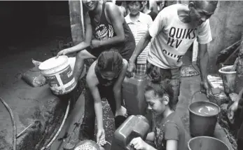  ?? NAZ UBANAN/SS-CDO ?? IN CAGAYAN DE ORO. Residents of Barangay Consolacio­n line up for water to clean the mud from their homes a day after Tropical Storm Vinta flooded the village.