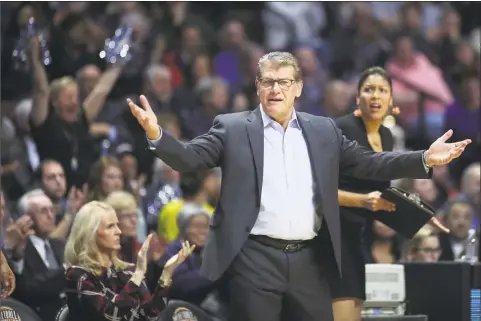  ?? Tim Clayton - Corbis / Corbis via Getty Images ?? UConn women’s basketball coach Geno Auriemma works the sideline while recording his 1,000th win as head coach of the team during the Naismith Basketball Hall of Fame Holiday Showcase game against the Oklahoma Sooners on Dec. 19, 2017, at the Mohegan Sun Arena in Uncasville.