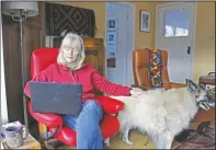  ?? (AP/Gillian Flaccus) ?? Crowley works on her laptop at her home with Mollie at her side in Hood River.