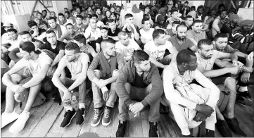  ??  ?? File photo shows migrants waiting to disembark from the Vos Hestia ship as they arrive at the Crotone harbour, after being rescued by a ‘Save the Children’ crew in the Mediterran­ean sea off the Libya coast, in Crotone, Italy. — Reuters photo