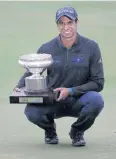  ?? AFP ?? Aaron Rai celebrates with the champion’s trophy in the rain.