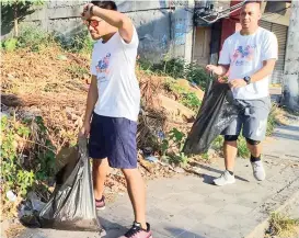  ??  ?? Architects pick up garbage along a street in downtown General Santos City.