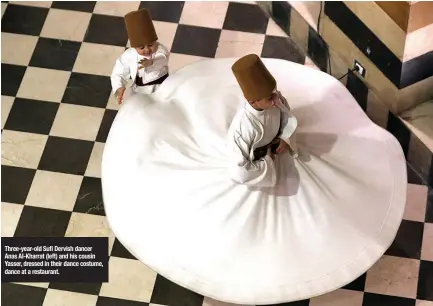  ??  ?? Three-year-old Sufi Dervish dancer Anas Al-Kharrat (left) and his cousin Yasser, dressed in their dance costume, dance at a restaurant.